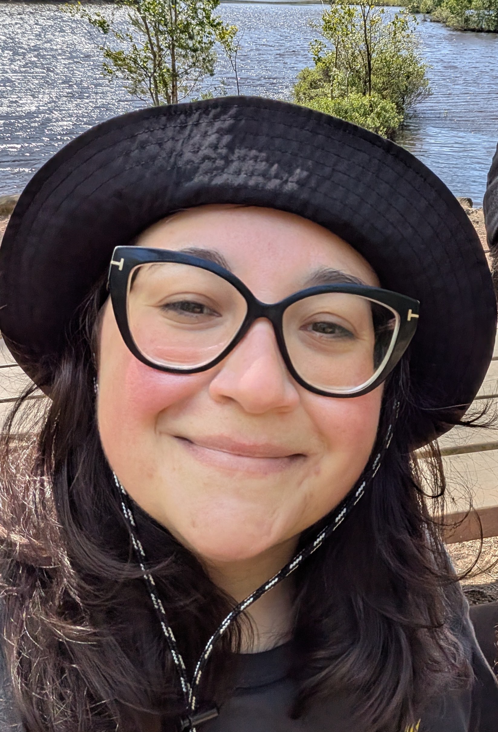 Photo of smiling Daniela wearing a bucket hat